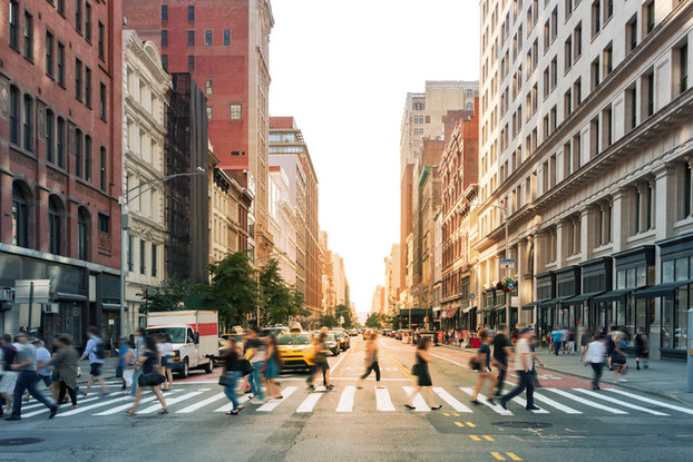 City street with a blurred image of people crossing in the crosswalk.
