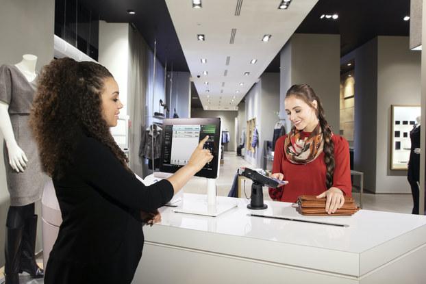 woman checking out with credit card at store