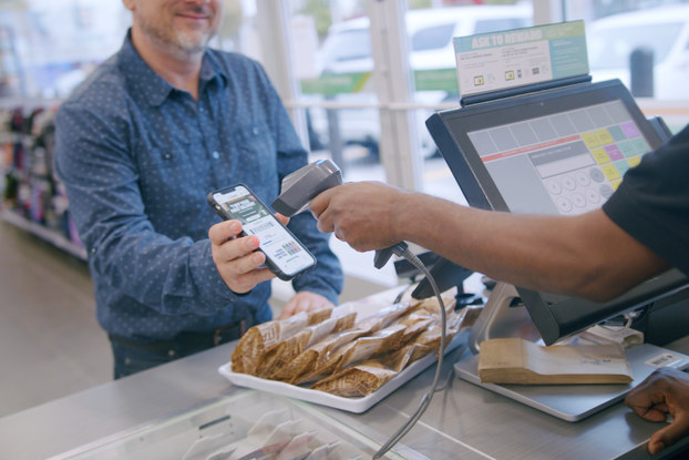 man scanning his phone app at 7-eleven