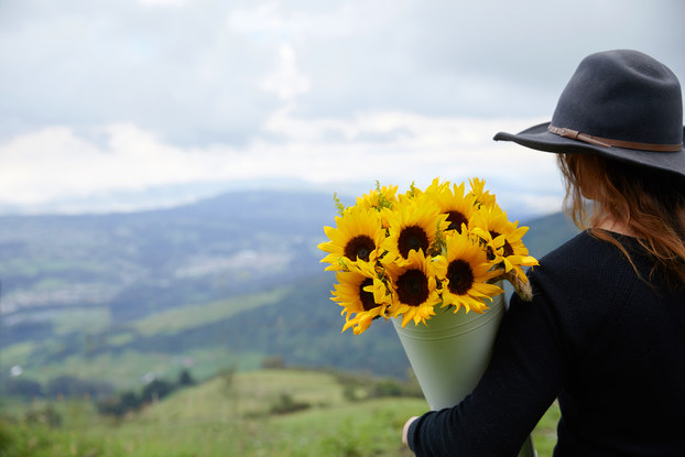 woman holding bouquet of sunflowers