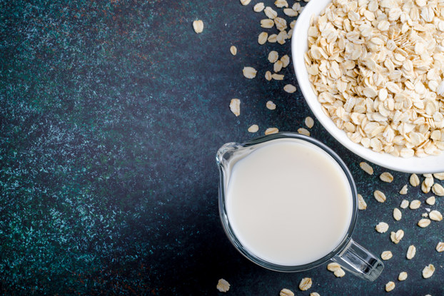 bowl of oats and cup of oat milk on a table