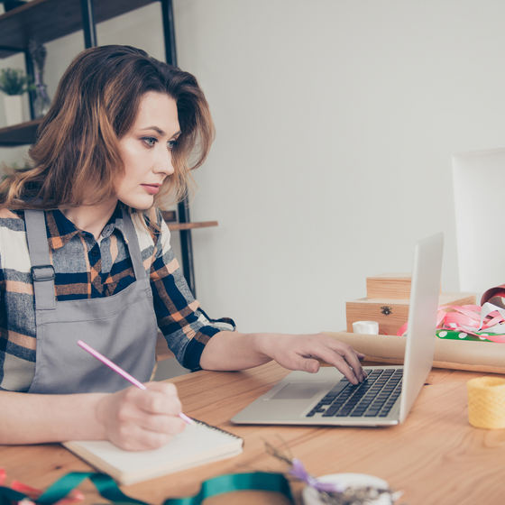 woman on laptop taking notes
