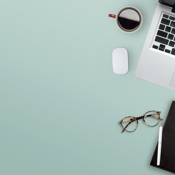 laptop, planner and coffee on a green desk