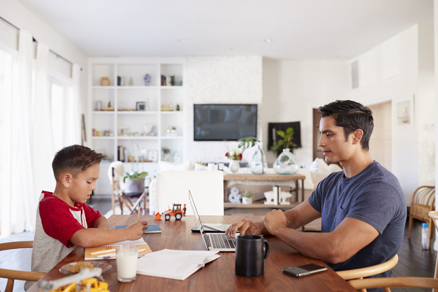 father working at kitchen table with son