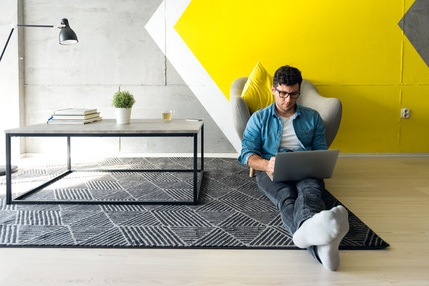 man sitting on floor with laptop