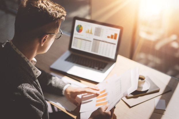 man at laptop with paperwork