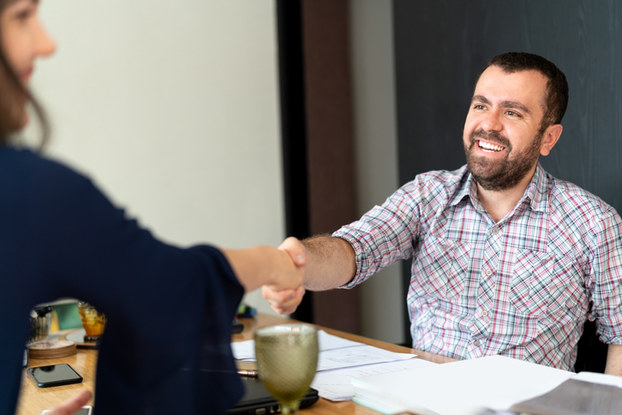 man shaking hands with woman at interview