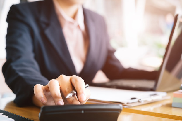 person in business suit performing calculations