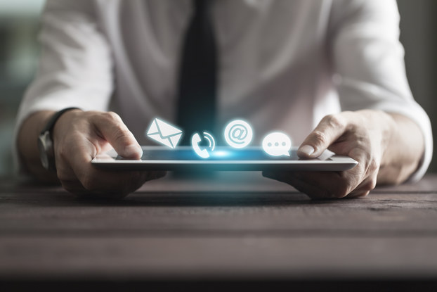 man holding tablet with communication icons