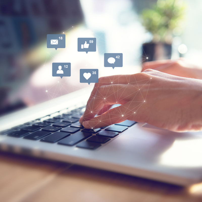laptop with social media icon images floating