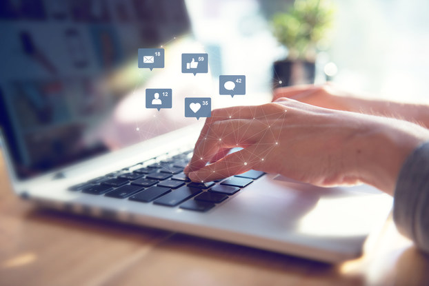 laptop with social media icon images floating