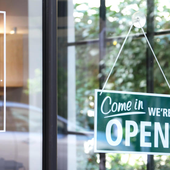 open business sign hanging on glass door