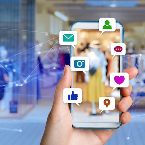 person holding up phone showing social media icons