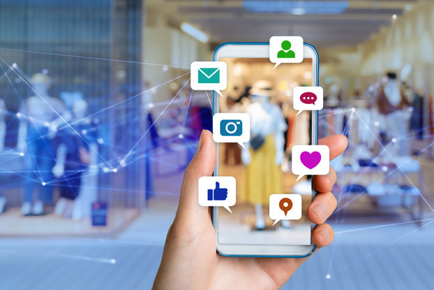 person holding up phone showing social media icons