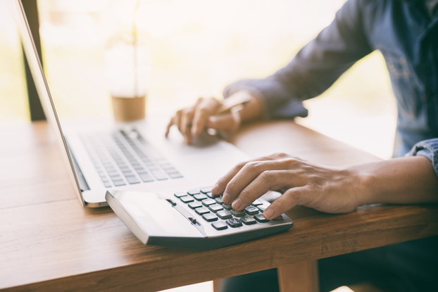 man using laptop and calculator