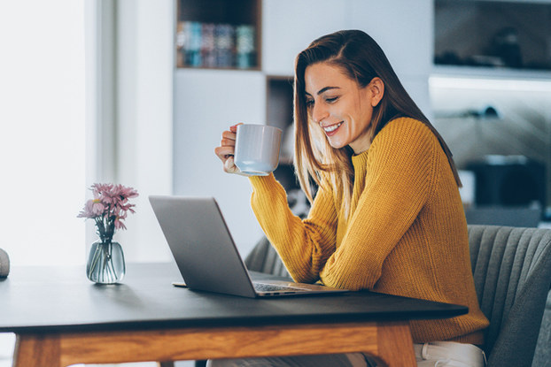 woman at table with laptop having coffee