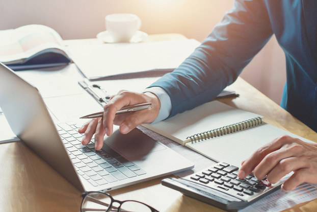 man using laptop and calculator