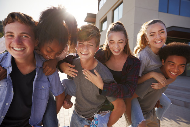 group of teens hugging and laughing