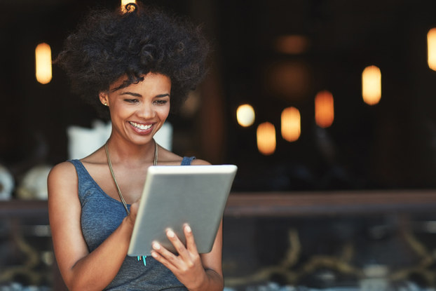 woman looking at tablet smiling