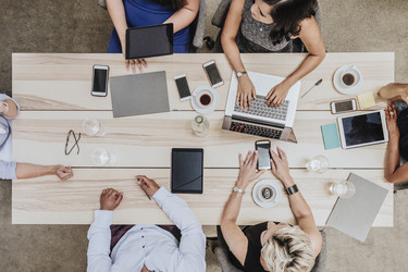 top view of coworkers sitting around a table