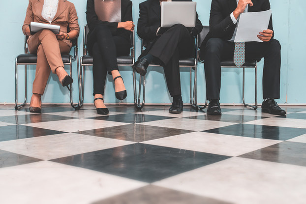 four applicants sitting in chairs waiting for job interview