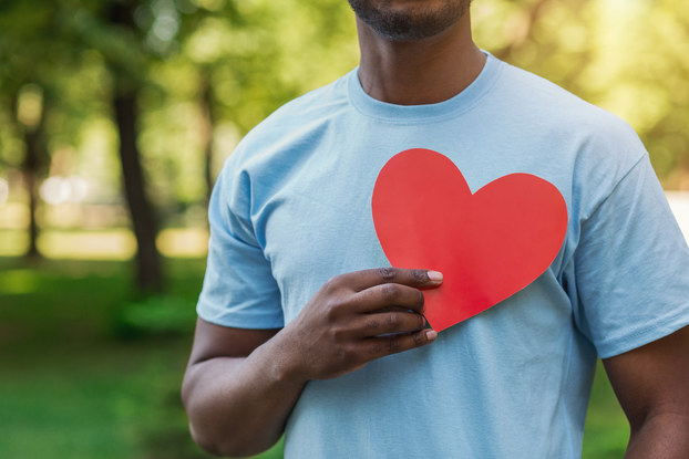volunteer holding cutout heart to chest