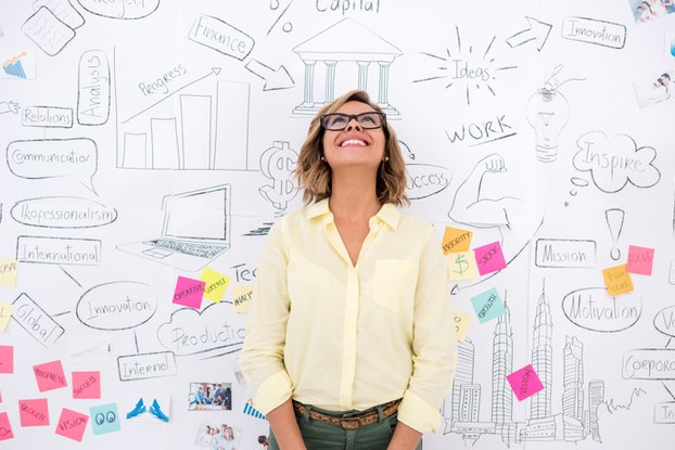 woman standing in front of whiteboard brainstorming