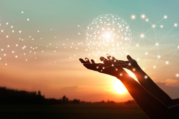 person's hands holding ball of global network icons