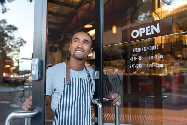 small business owner holding door to business open