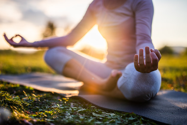 woman meditating on yoga mat