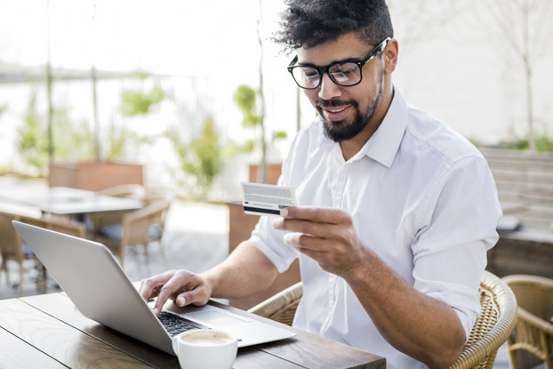 man paying for something on laptop with credit card