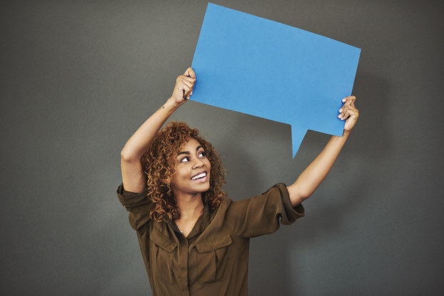 woman standing holding speech bubble