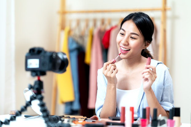 female influencer recording a video putting on makeup