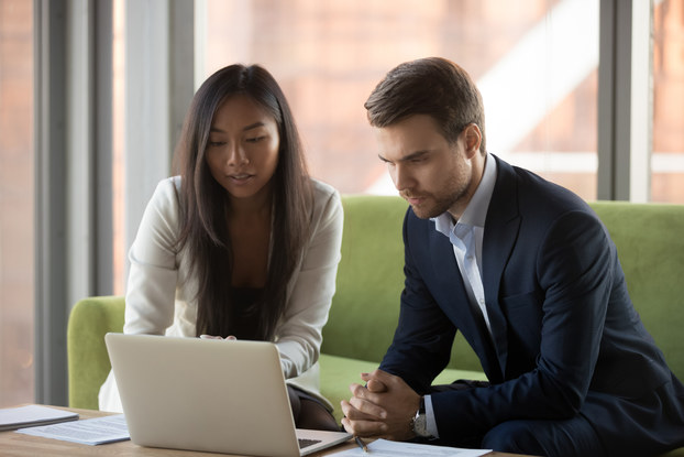 male and female coworkers looking at laptop