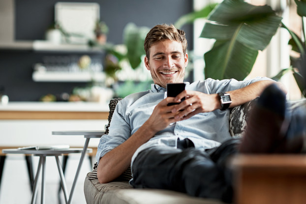 man relaxing on couch with phone