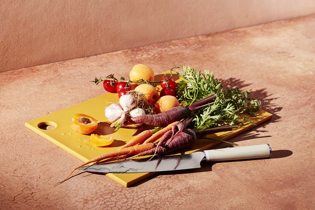 material kitchen knife and cutting board with vegetables