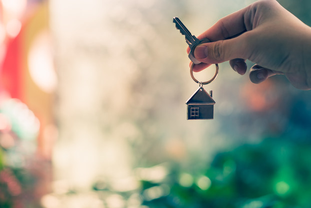 person holding key with house keychain
