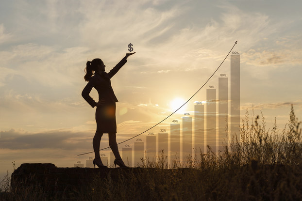 woman standing in front of a graph with increasing money