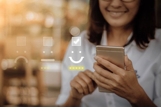 woman holding phone with positive customer service image