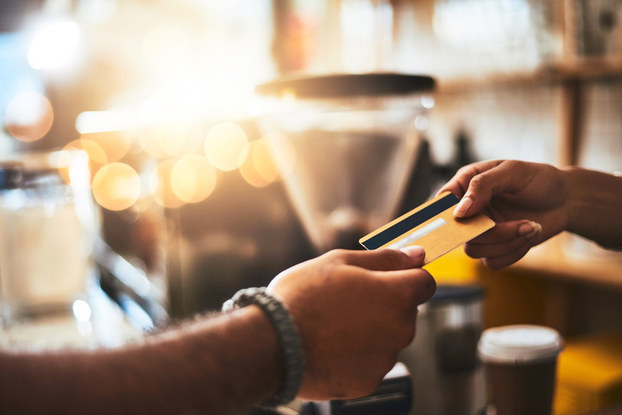 Women handing credit card to barista
