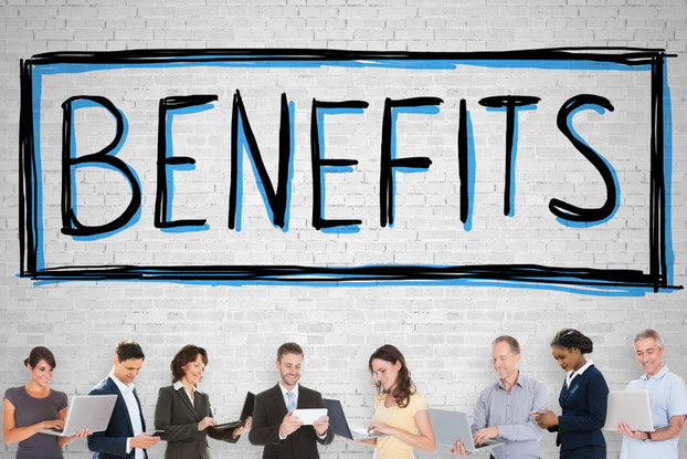 Employees standing under benefits sign