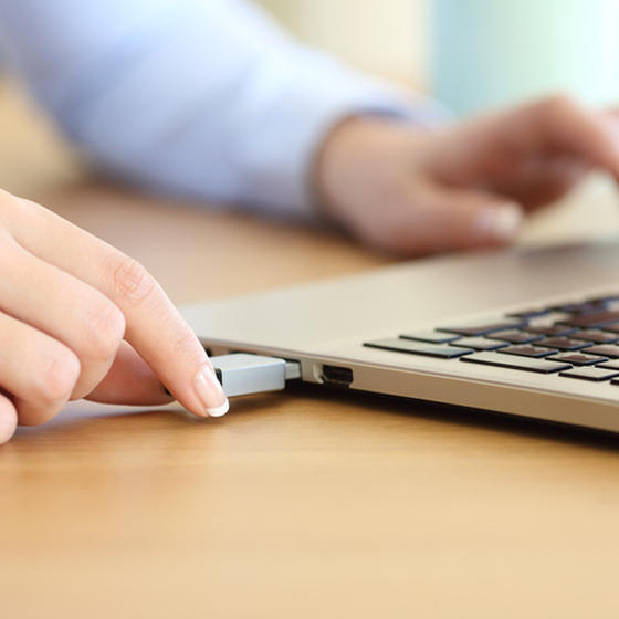 Workers plugging thumb drive into laptop