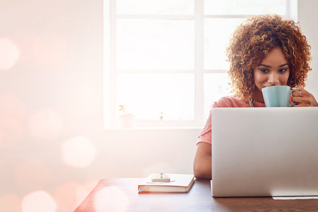 Woman with coffee using laptop