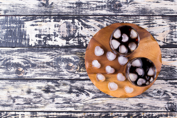 two glasses of soda with heart-shaped ice cubes on tray