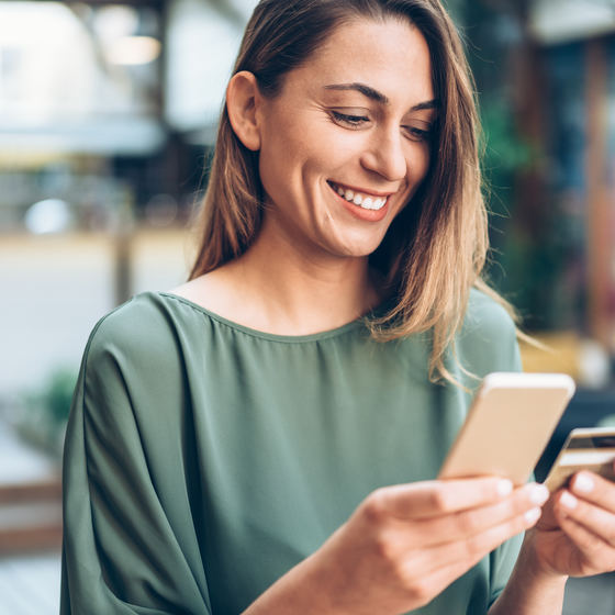 woman shopping on phone with credit card