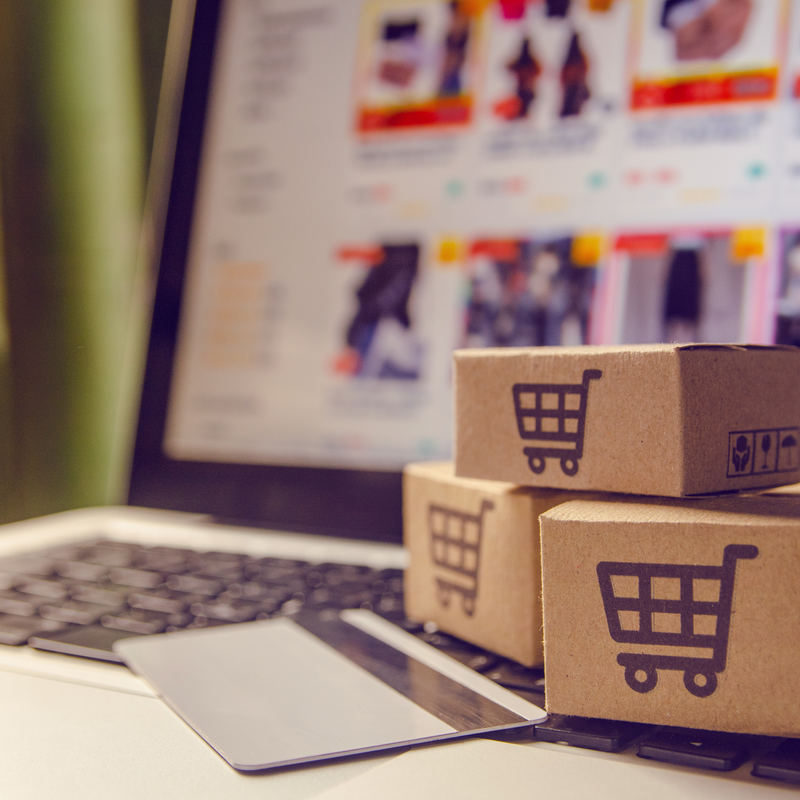 little boxes with shopping carts sitting on top of a laptop keyboard
