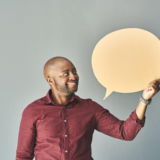 man holding speech bubble cutout