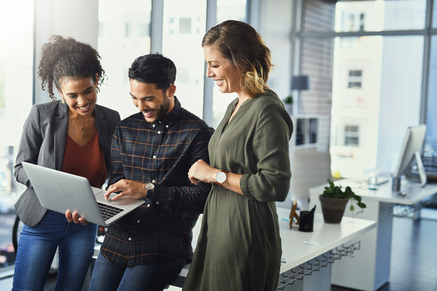 three coworkers looking at laptop