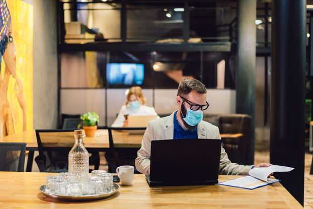 two employees working in office with masks on
