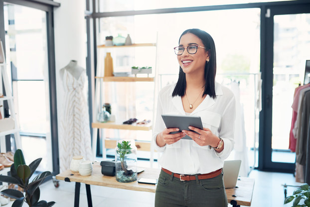 woman small business owner in shop on tablet